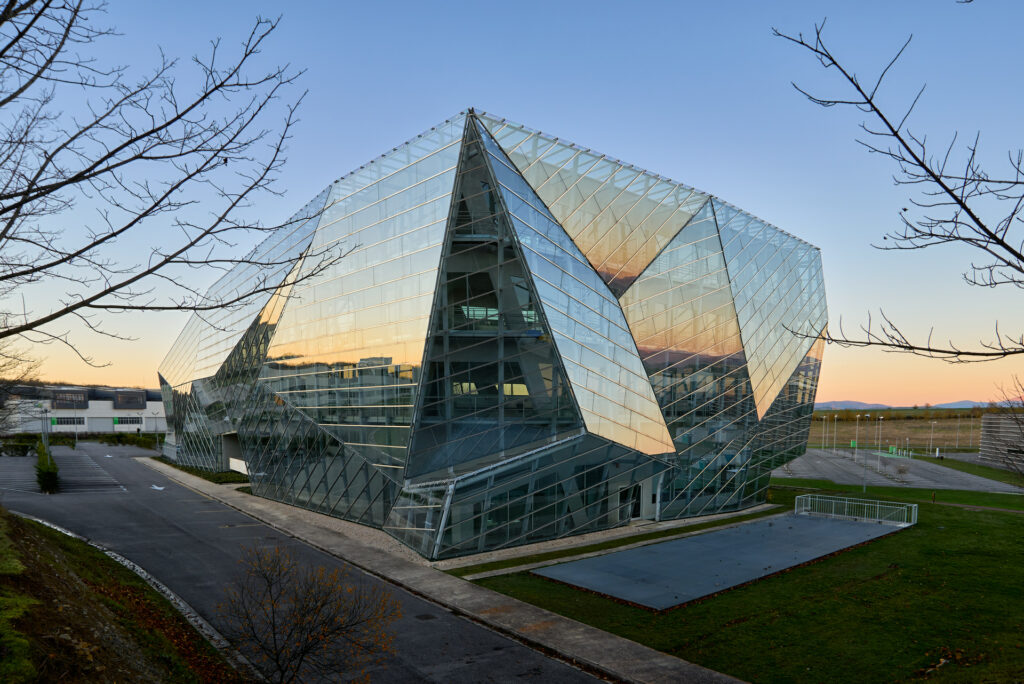 Fotografía de arquitectura exterior del edificio E8 en el Parque Tecnológico de Álava, con fachada de vidrio y geometría contemporánea, realizada por Zigor Astigarraga, fotógrafo de arquitectura e interiorismo en Durango, Bizkaia.